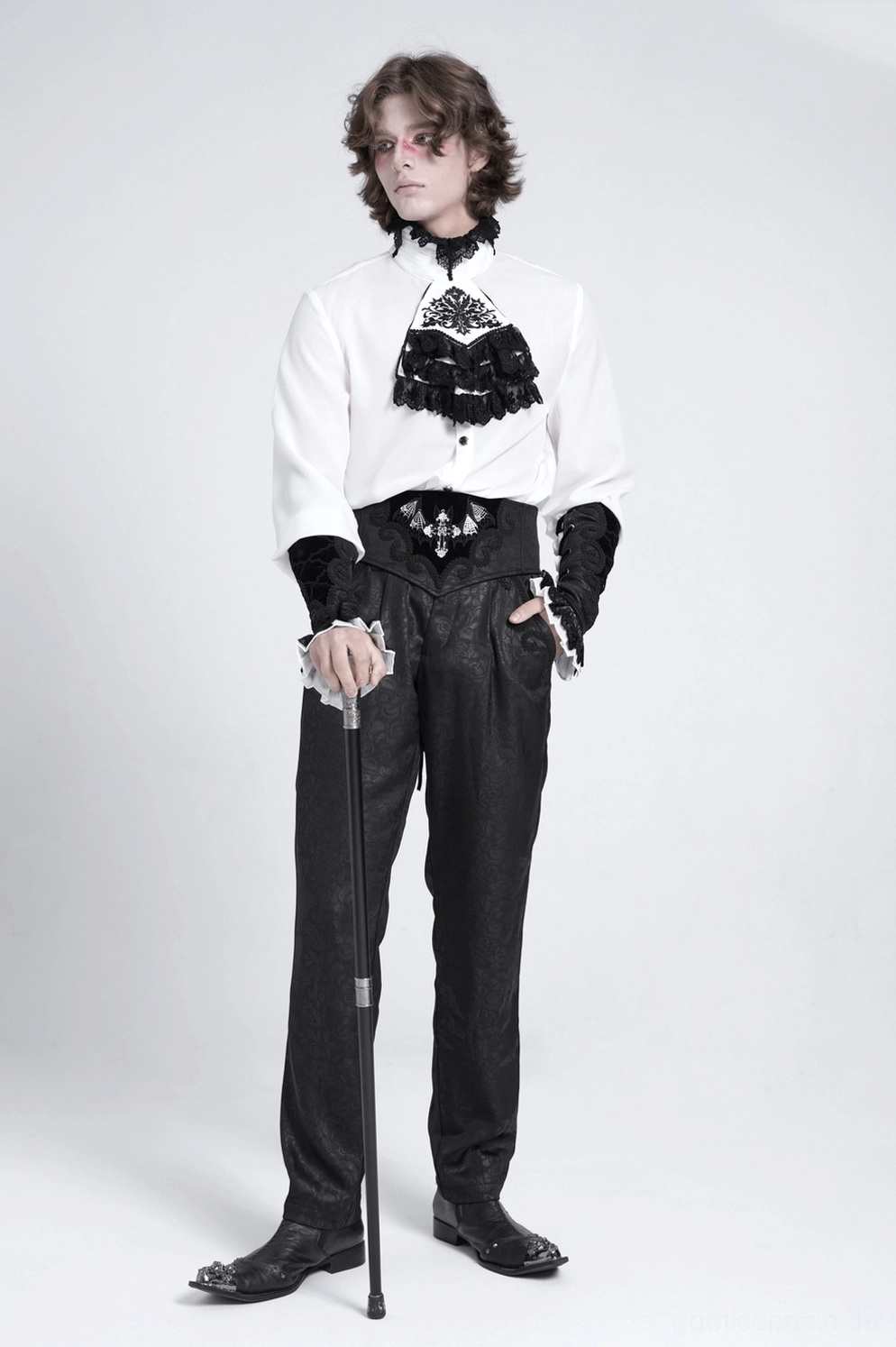 Goth-Armschuhe getragen von männlichem Model in formalem Goth-Ensemble mit hochsitzenden Hosen und passendem Jabot-Kragen, Vorderansicht-Studiofoto mit weißem Hintergrund