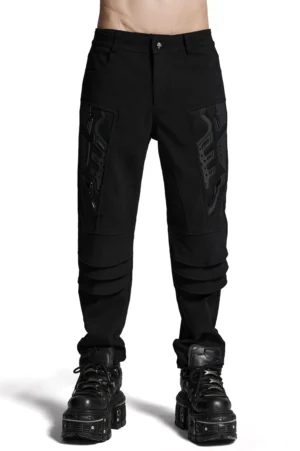 Schwarze Gothic Cargo Hose Vorderansicht auf männlichem Model mit 3D-Oberschenkel-Armor-Patches und mehrschichtiger Knienkonstruktion, getragen mit plattform Combat Boots und gotischen Accessoires