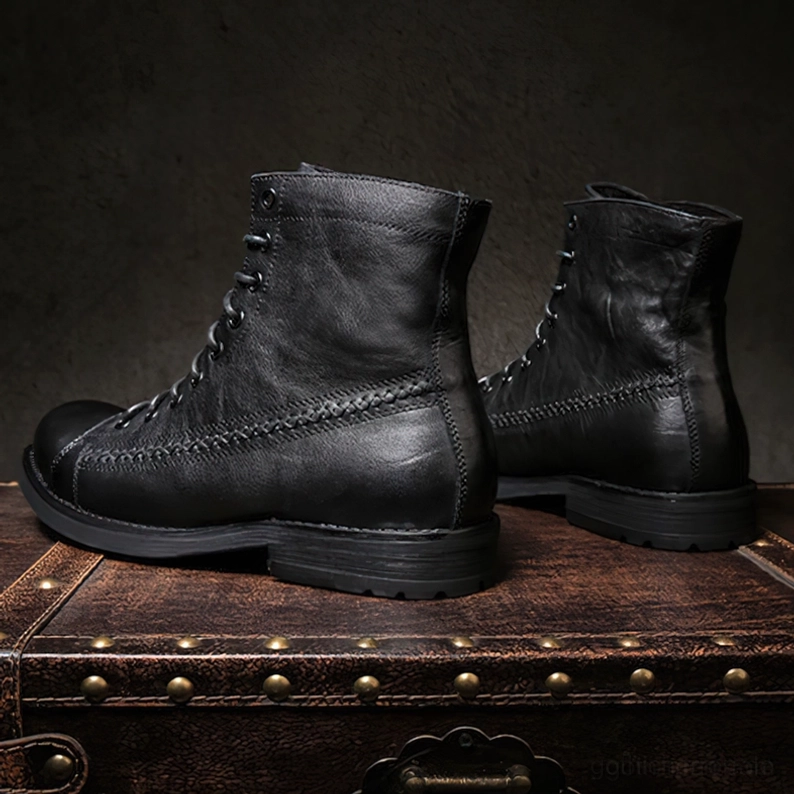 Schwarze Vintage Gothic Schnürstiefel mit dicker Gummilaufsohle und Profil auf vintage Leder-Koffer