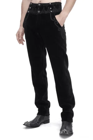 Schwarze gotische Corduroyhose mit ornamentaler Spitzentaille, Vorderansicht in Dreiviertelansicht auf männlichem Model im Studiofoto, zeigt Details der Scrollverzierung und Edelsteinknöpfe
