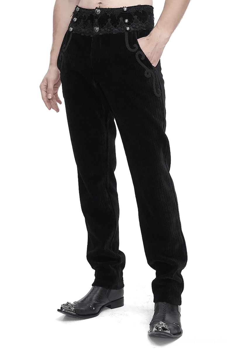 Schwarze gotische Corduroyhose mit ornamentaler Spitzentaille, Vorderansicht in Dreiviertelansicht auf männlichem Model im Studiofoto, zeigt Details der Scrollverzierung und Edelsteinknöpfe