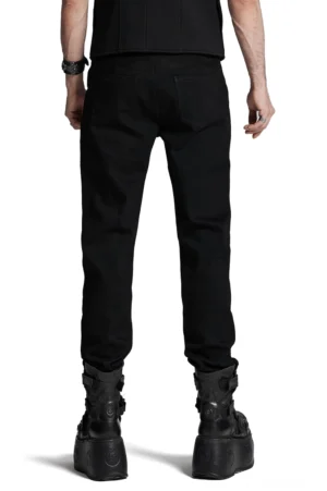 Schwarze Gothic-Denim-Hose von hinten mit Patchwork-Suede-Panels, taillierten Gesäßtaschen und strukturiertem Rückenteil, Rückansicht auf männlichem Model