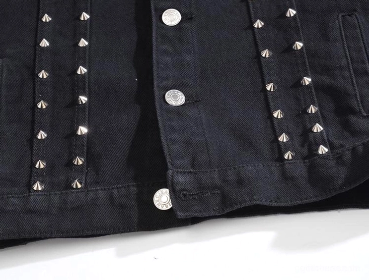 Vordertaschen- und Placket-Detail der schwarzen Studded Denim Weste mit Reihen von silbernen Spike-Nieten, ärmellose Waistcoat-Konstruktion, gotisches Design-Detail