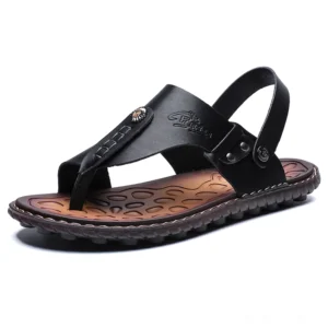 Schwarze Split-Leder Gothic Fußgelenkbinder-Sandalen für Herren, Slip-On Flip-Flops mit metallischen Ziernägeln, Seitenansicht Studio-Fotografie auf weißem Hintergrund