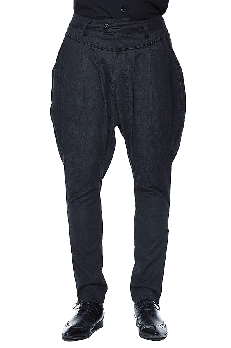 Schwarze Gothic-Haremshose mit Jacquard-Webmuster und Kellerfalten, Frontansicht auf männlichem Model, zeigt hohen Bund, voluminöse Oberschenkel und verjüngtes Knöchelbündchen mit eleganten schwarzen Lederschuhen