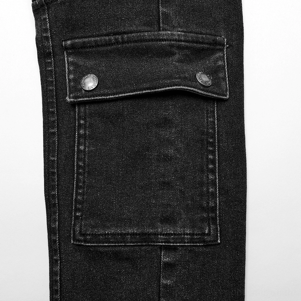 Schwarze gothic skinny jeans tasche detailaufnahme nahaufnahme - zweifach metalldruckknopf-klappentaschendesign auf gewaschenem schwarzem denim material