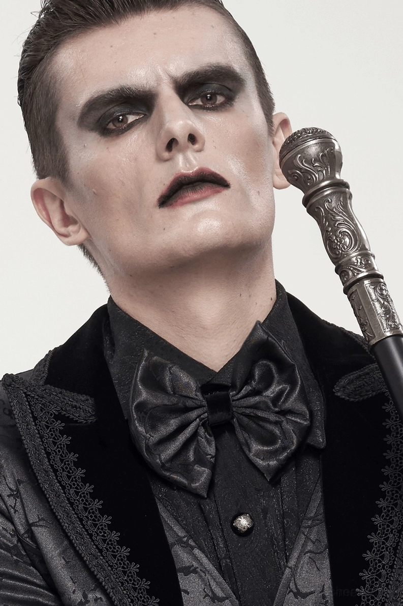Männliches Model mit schwarzer Gothic Krawatte, Spazierstock und Samtkante-vertrimmtem gotischen Anzug, Dreiviertel-Porträt zeigt komplette retro-gotische Gesamtstilistik