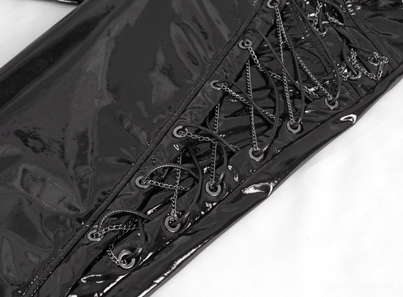 Detaillierte Nahaufnahme integriertes Kettenschnürung-System der schwarzen Gothic-Kunstleder-Lederhose mit Metallöse-Verschlüssen, Kettenglieder-Design und hochglänzender schwarzer Kunstleder-Oberflächenstruktur für Industrial-Ästhetik