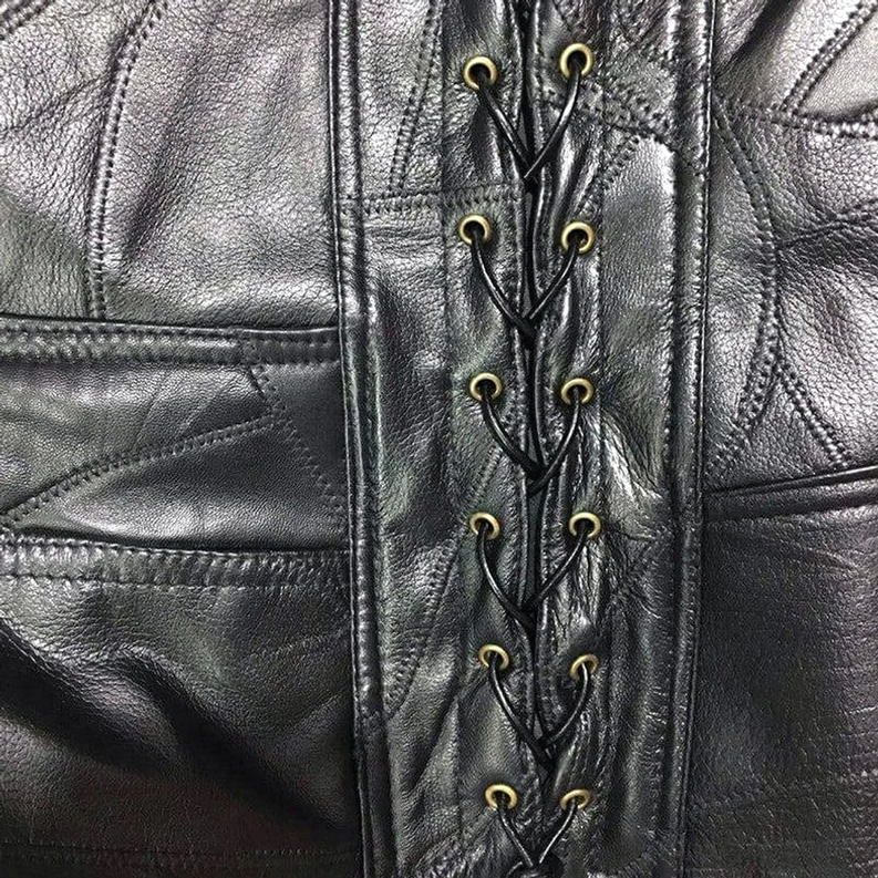 Prägeprägter Bison-Goldener Metallknopf Nahaufnahme auf schwarzer Gothic-Leder Biker Weste mit Hardware-Details