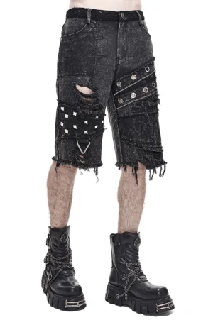 Schwarze säuregewaschene Gothic-Punk Denim Shorts mit Metallnieten und zerrissenen Details Vorderansicht Seitenwinkel auf männlichem Modell Studiofotografie