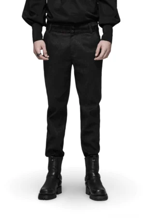 Schwarze gothische Jacquard Slim-Fit Röhrenhose mit roter Spitzenverzierung am Model von vorne, kombainiert mit schwarzem Hemd und Combat Boots