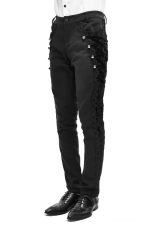 Schwarze Gothic Röhrenhose mit Jacquard-Webung und Spitzenseitenpaneele, Seitenansicht auf Modell, elegante Slim-Fit-Silhouette mit Metallverzierungen und weißem formalen Hemd