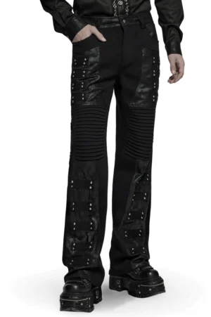 Schwarze gothische Schlaghose mit strukturierten Faltenknien und Niertenriemen - Vorderansicht im Dreiviertelprofil auf männlichem Model mit chunky Platform Boots