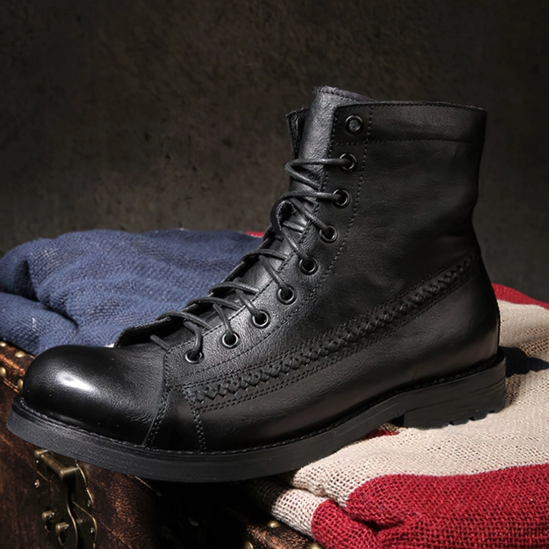 Schwarze Gothic Schnürstiefel mit Brogue-Steppdetails an der Zehenklappe auf gestrickten Stoffen und Vintage-Holztruhe