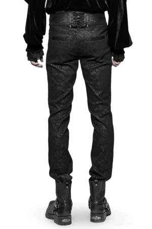Schwarze Gothic-Skinny Jeans mit dramatischer Schnürung – Rückansicht auf Modell mit schwarzem Samttop und Kampfstiefeln zeigt korsetartige Rücken-Schnürung mit Metallösen, geflochtener Kordel, geprägte Ledertaillenband und Gothic-Subkultur-Styling