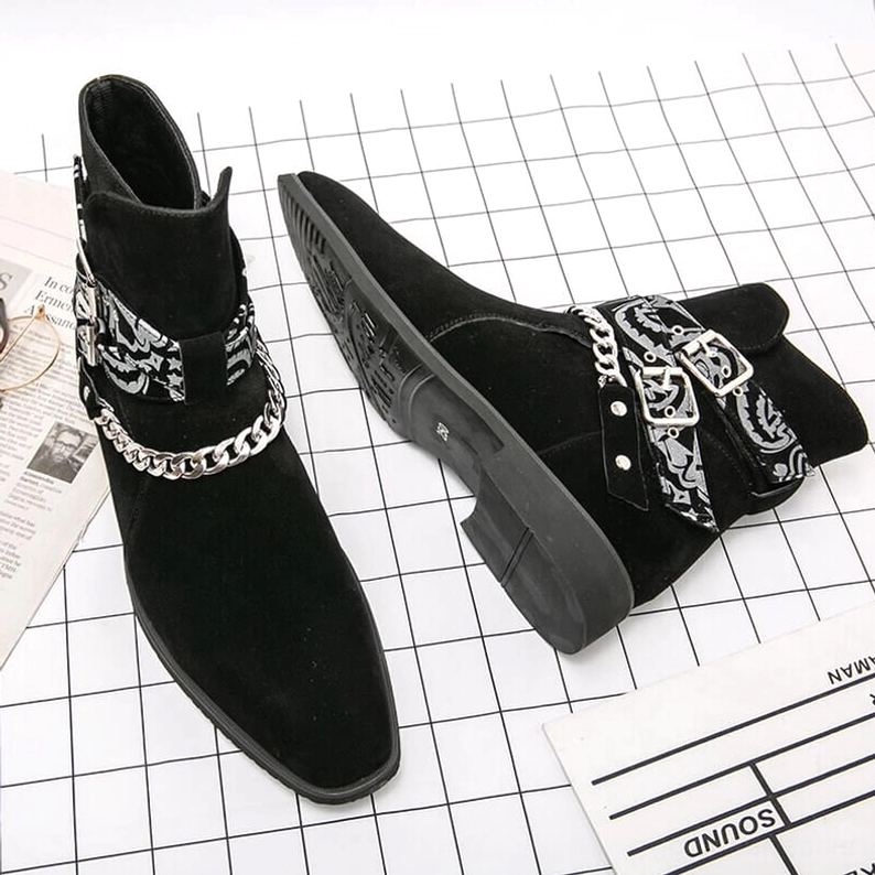 Schwarze Kunstvelousr gotische Knöchelstiefel Flatlap auf Millimeterpapier mit dekorativen Riemen und Kettenhardware sichtbar