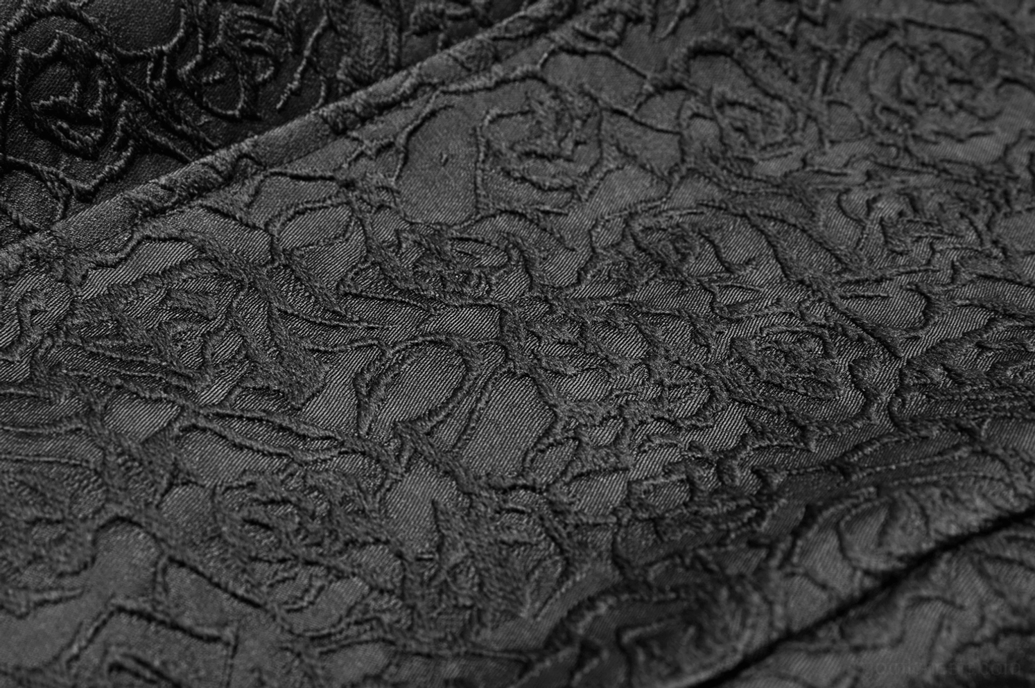 Extreme Nahaufnahme schwarze Gothic-Weste zeigt intricate florales Jacquard-Webmuster und matter schwarzer Oberflächenfinish