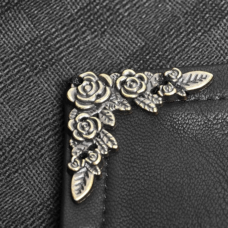 Nahaufnahme Rosenförmige Metallverzierung Lappenornament auf schwarzer Gothic Steampunk Anzugweste – Gravierte Dekoration an PU-Leder Kante