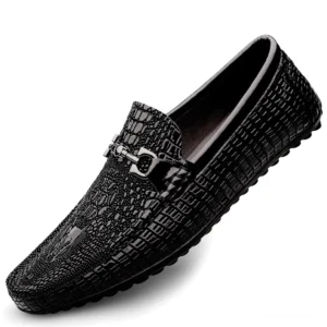 Schwarze Herren-Gothloafer mit Krokoleder-Prägung und glänzender Metallbittrense Verzierung, Drei-Viertel-Schrägansicht auf weißem Hintergrund, elegantes Slip-On-Design