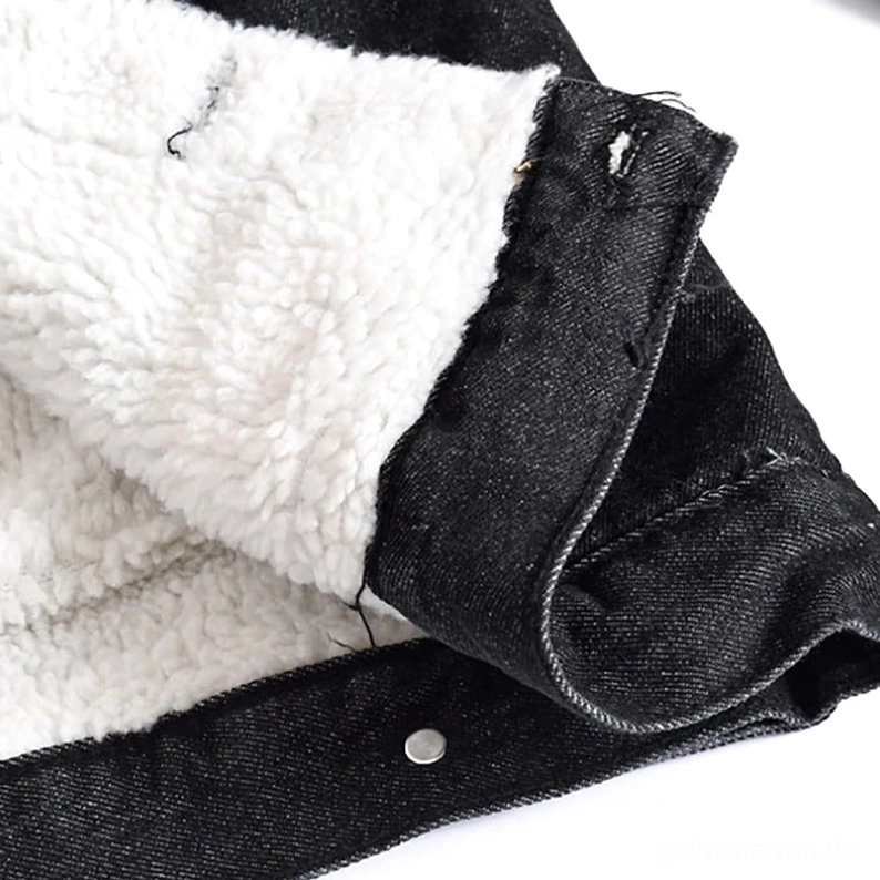 Schwarze Denim-Jacke innere Sherpa-Fleece-Fütterung Nahaufnahme zeigt dicke weiße Thermische Isolierungsschicht und Metalldruckknopfverschluss, gotische Handwerkskunst Detail