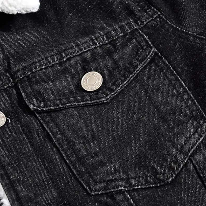 Schwarze Denim-Jacke Brusttasche Detailansicht mit Metalldruckknopf und schwarzer Denim-Textur, gotisches Design Element Handwerkskunst