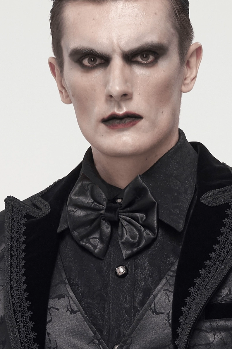 Männliches Model Nahaufnahme mit schwarzer Jacquard Gothic Krawatte, gotisches Makeup und formale gotische Kleidung mit Weste und Blazer, elegante Detailansicht