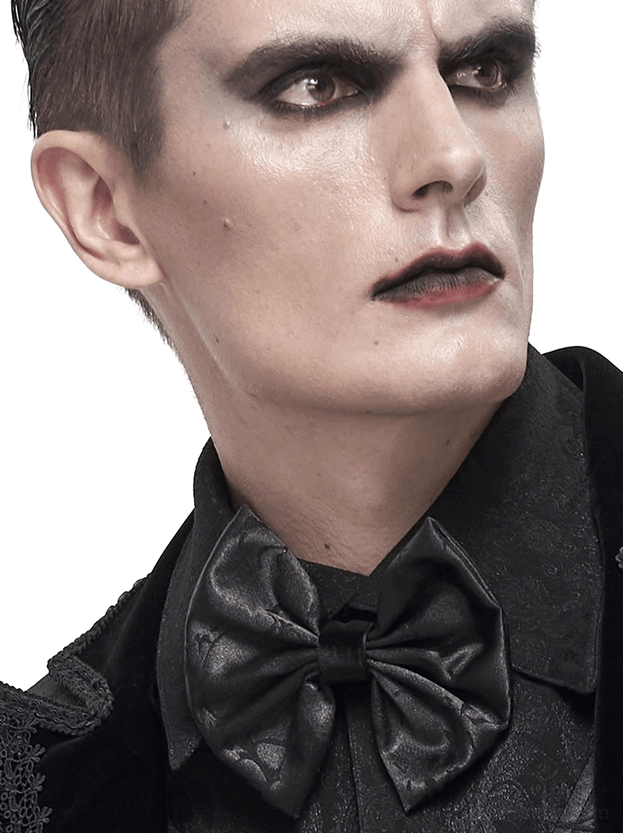 Männliches Model mit schwarzer Jacquard Gothic Krawatte und Schnürverschluss auf formaler schwarzer Kleidung, Dreiviertel-Studioporträt mit gotischem Makeup und eleganter Stilisierung