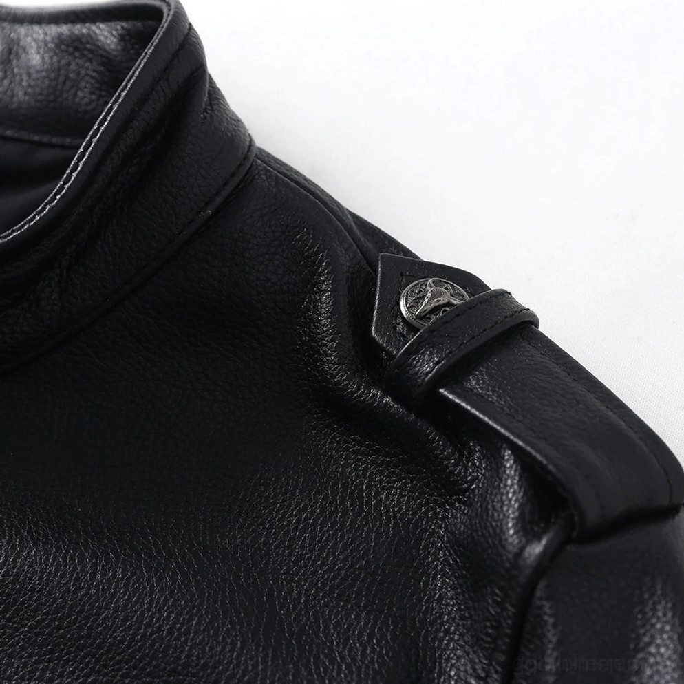 Nahaufnahme der Pebble-Leder Körnung und Metallknopf-Detail an der Schulter-Epaulette der schwarzen Gothic-Jacke