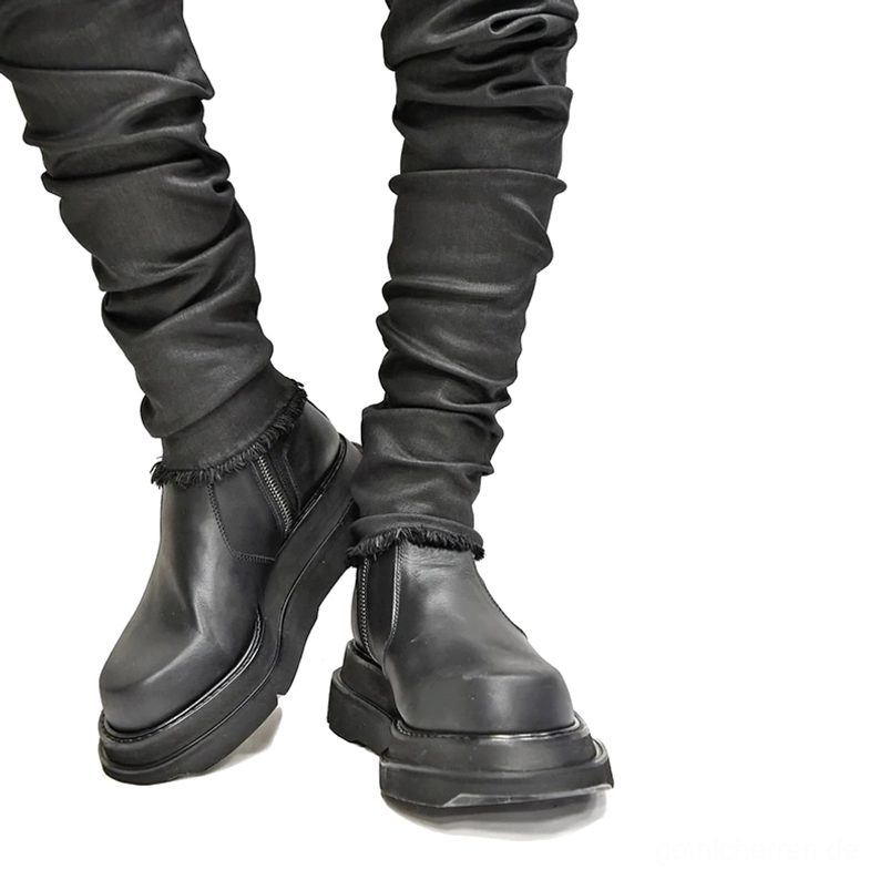 Schwarze Plateau-Stiefel getragen mit lockerer grauer Denim an männlichem Model in Dreiviertel-Vorderwinkel, zeigt Gothic Casual Styling und mühelose Dunkelheit Ästhetik, Alltagslook