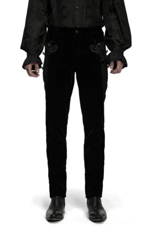 Schwarze Samtröhrenhose mit Edelsteinknöpfen und ornamentaler Spitzentrim, vollständige Vorderansicht auf männlichem Model in Rockstil-Outfit