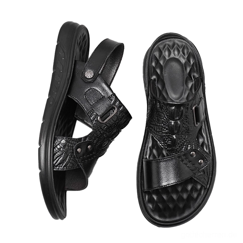 Schwarze Ledersandalen Flachlage Draufsicht zeigt gestepptes Fußbett-Design und Dual-Funktionalität mit sichtbarer Schnallen-Konstruktion