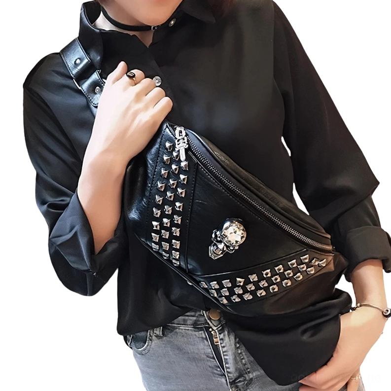 Frau trägt schwarze Schädel-Nietenguerteltasche als Crossbody über schwarzem Langarm-Shirt und grauer Jeans tägliches Gothic-Fashion-Accessoire