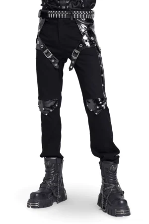 Schwarze studded harness gothic lederhose vorderansicht mit metallschnallen-riemen und knie-nieten auf modell in studiofotografie