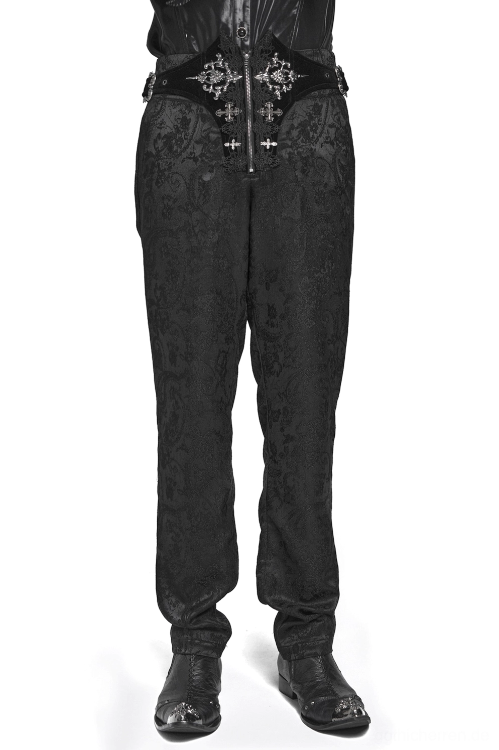 Mann trägt schwarze viktorianische Gothic Cargohose mit silberner Kreuzstickerei und Schnürtaille, Vordertotalansicht im Studio mit schwarzen Lederstiefeln