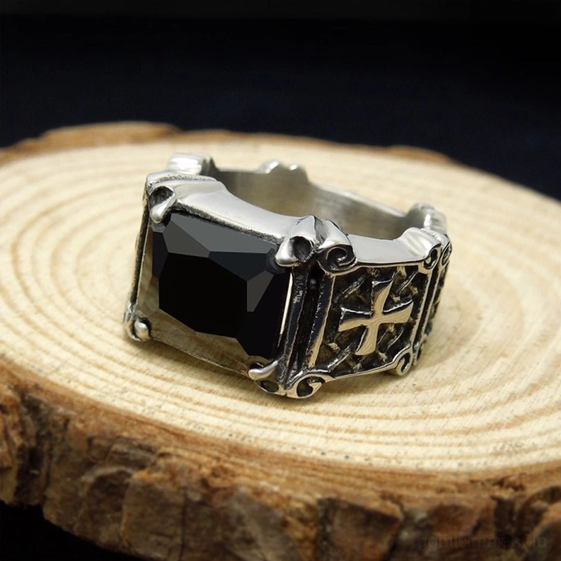 Schwarzer Edelstein keltischer Kreuz Ring auf rustikalem Holzdisplay Draufsicht gravierte Kreuzdetails oxidiertes Edelstahl Gothic
