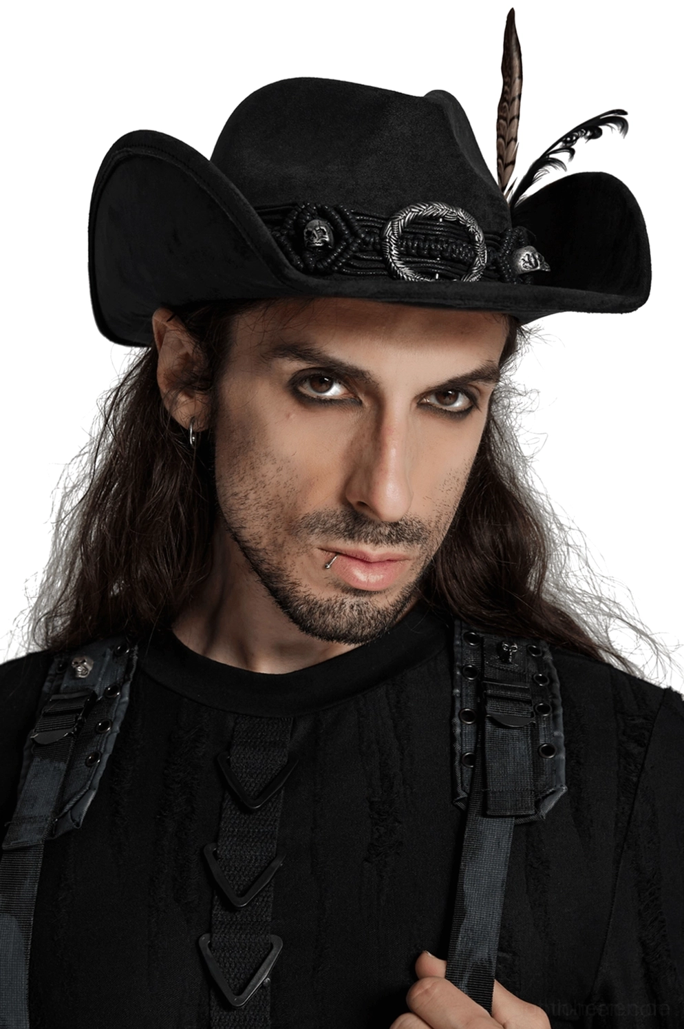 Schwarzer Gothic-Hörner-Cowboyhut mit geschwungenen Hörnern, intrikat gearbeiteter Totenkopf-Schnallen am geflochtenen Hutband und schwarzer Federkaskade, getragen von männlichem Modell mit langen schwarzen Haaren in gotischer Kleidung, Nahaufnahme Vorderansicht