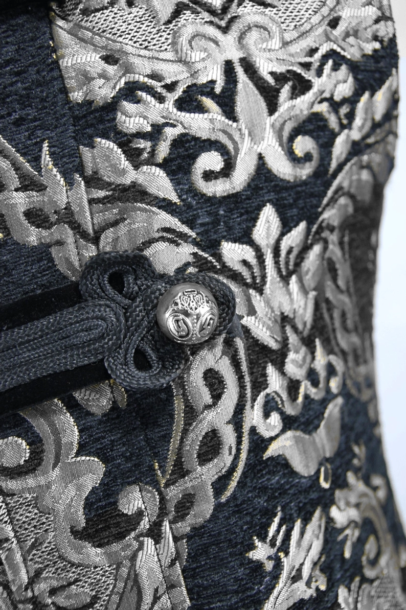 Schwarzer silberner Damast-Jacquard Gothic-Mantel – Nahaufnahme Metallknebelverschluss Detail, polierter silberner Metallknopf auf schwarzem Jacquard-Hintergrund mit Damast-Muster