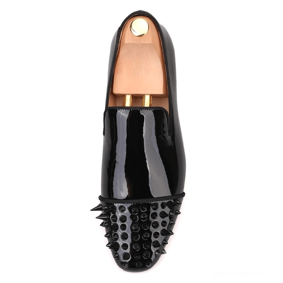 Flachlage Draufsicht auf einen schwarzen Lackleder Gothic Loafer mit Spike-verzierte Zehenkappe und elegantes Slip-On-Design