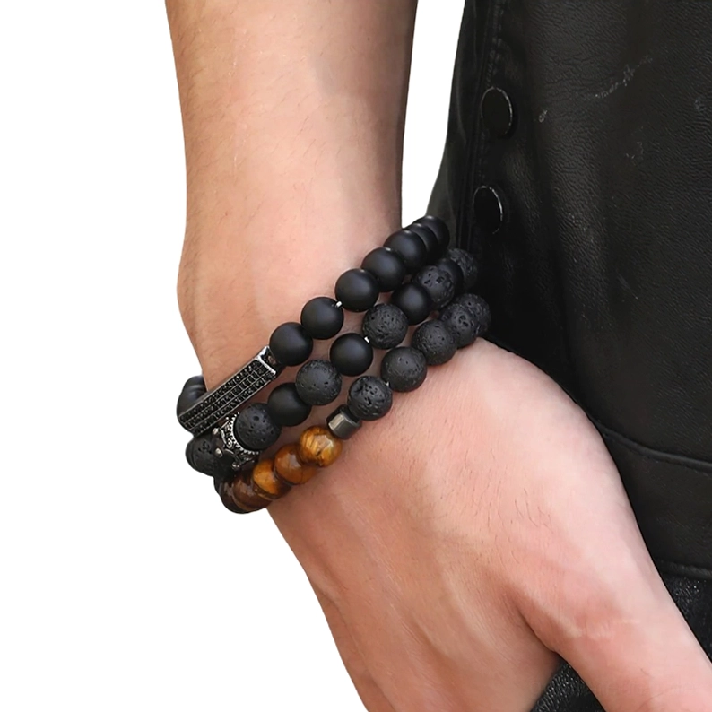 Unisex schwarzes Onyx Perlen-Armband mit gravierter Metallkrone auf Wrist getragen neben schwarzer Lederjacke, Seitenprofil-Ansicht zeigt alternative Schmuck-Ästhetik