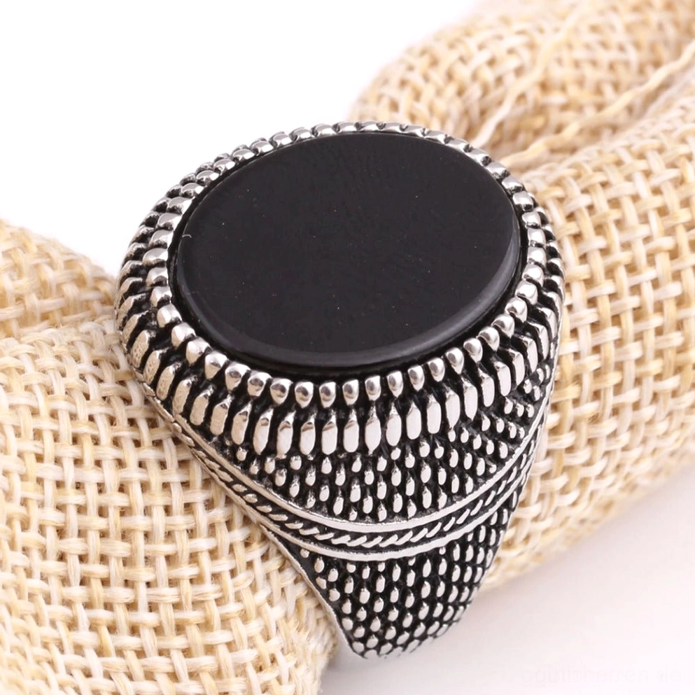 Schwarzer Onyxring Gothic Siegelring flacher Stein Aufsicht Leinengewebe Hintergrund Studio