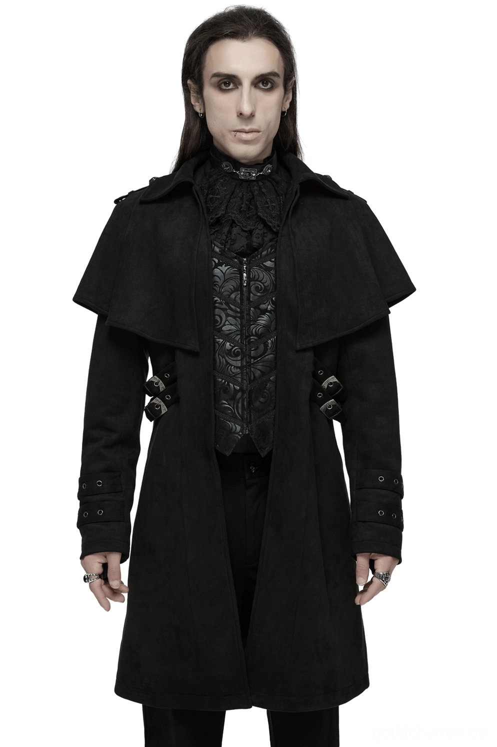 Schwarzer Suede Gothic Mantel mit dekorativen Schnallen Frontansicht auf männlichem Model, zeigt Cape-Kragen, handgeschnitzte Manschettenriemen und bestickte innere Westenpaneldetails