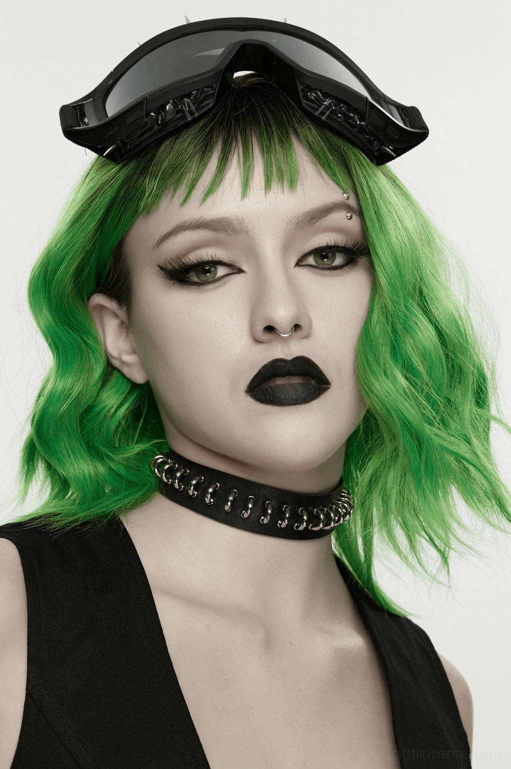 Alternative Styling-Aufnahme Model trägt schwarzes Lederhalsband mit Silberringen kombiniert mit Goth-Accessoires und grünem Haar