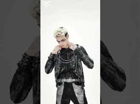 Schwarzes Gothic-Punk hooded top mit Metallketten-Dekorationen Halbkörper-Aufnahme auf blondem männlichem Model vor dunklem Studio-Hintergrund
