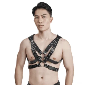 Schwarzes PU-Leder Harness Vorderansicht auf männlichem Model mit gekreuzten Bruststreifen, Metall-Kontaktschleifen und verstellbaren Schnallen – Gothic Ledergeschirr