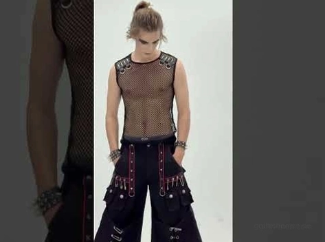 Schwarzes Netz-Muskelshirt Styling-Inspiration mit Bondage-Trousers und mehreren Layered-Armbändern auf männlichem Goth-Model