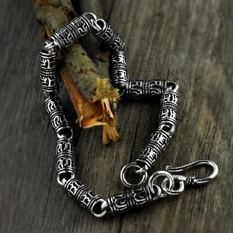 925er Sterling Silber Armband Detailaufnahme, okkulte Gravuren auf zylindrischen Perlen, Holzuntergrund low-angle close-up, zeigt Hakenverschluss und antikes Metall-Finish
