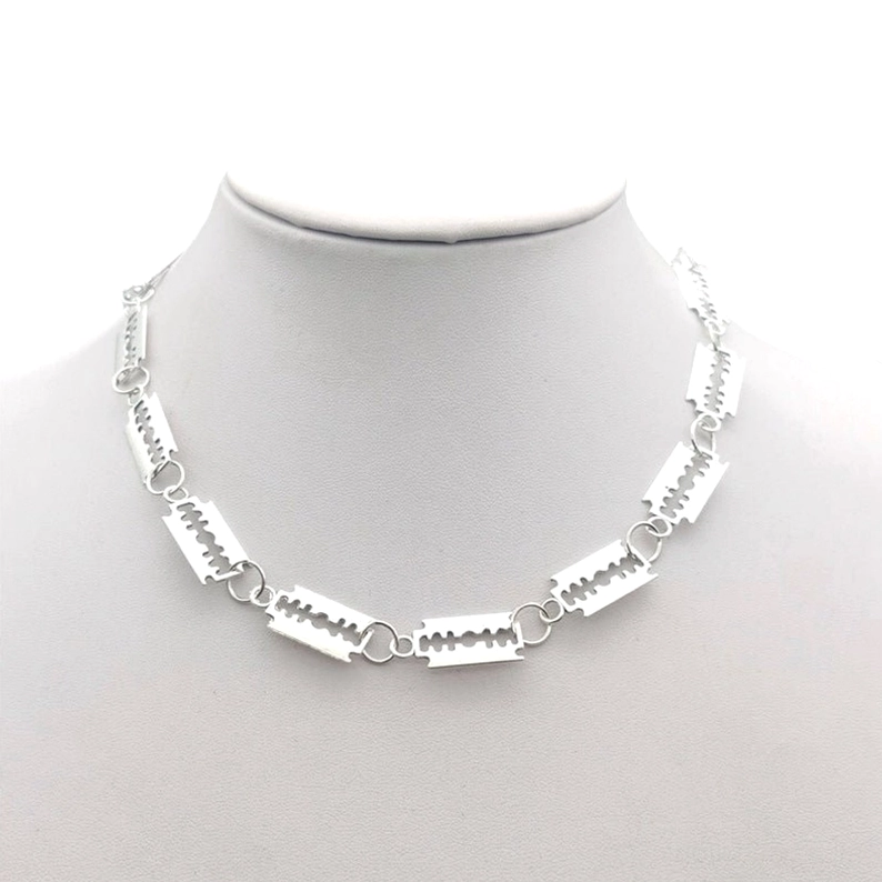 Silberne Rasierklingen-Gothic-Choker-Kette mit 14 Klingenelementen an mannequin Hals, Frontansicht zeigt Industrial-Ästhetik und verstellbaren Karabinerverschluss