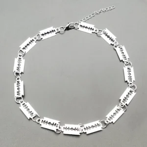 Overhead Draufsicht der silbernen Klingen-Choker auf grauem Hintergrund, zeigt gesamte Kettenlänge, Klingendetails, verstellbare Verlängerungskette und Karabinerverschluss