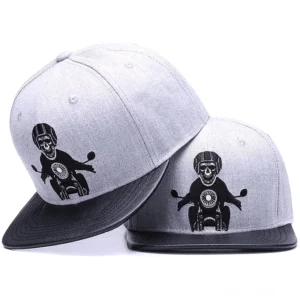 Skeleton Motorcyclist Gothic Snapback Cap - Zwei überlagerte Totenkopf-Biker-Kappen in Grau und Schwarz mit kunstvoll besticktem Motorradfahrer-Design und schwarzem Kunstleder-Schirm