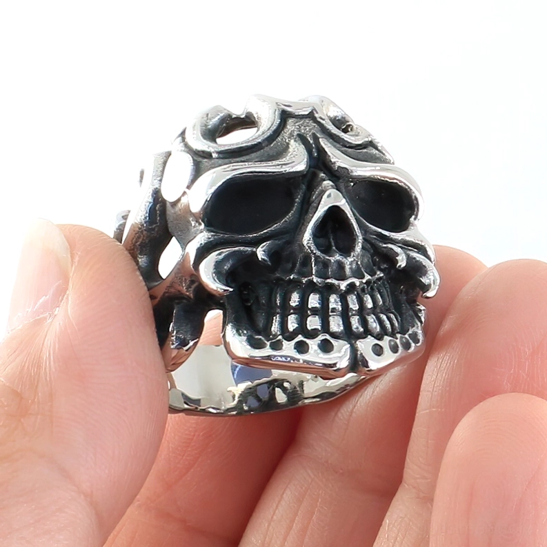 Nahaufnahme Seitenansicht des Gothic Skull Edelstahlrings in Händen gehalten, zeigt detaillierte Tribal-Hohlschnitzereien, polierte Oberfläche und intricate Schädelverzierungen